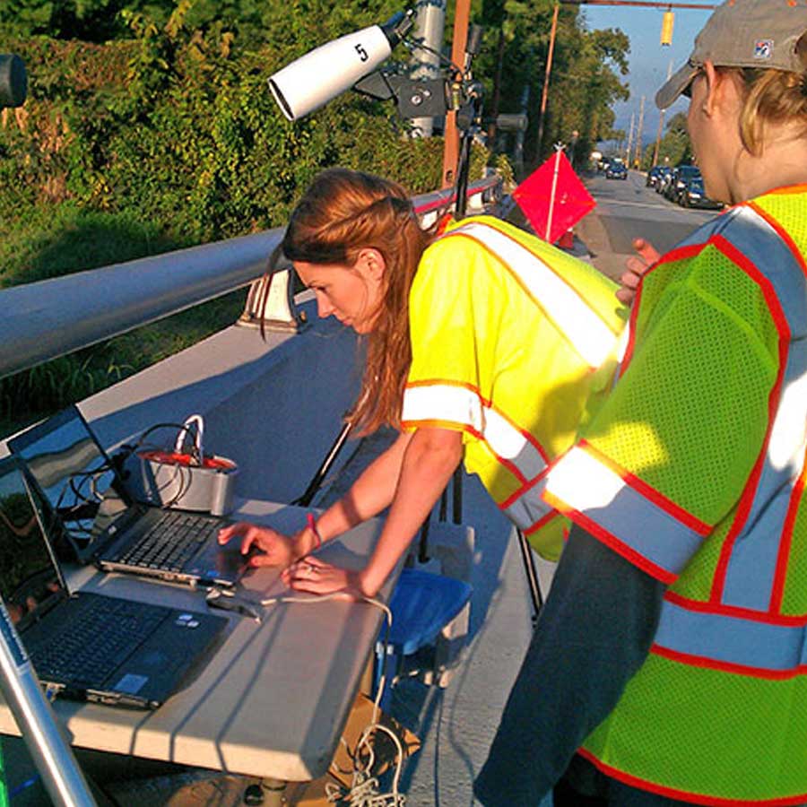 Students photographed in a lab setting, measuring traffic signal activity on the road.