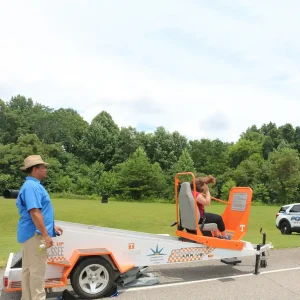 A photo of the Center for Transportation Research's Seatbelt Convincer with a girl in the seat.