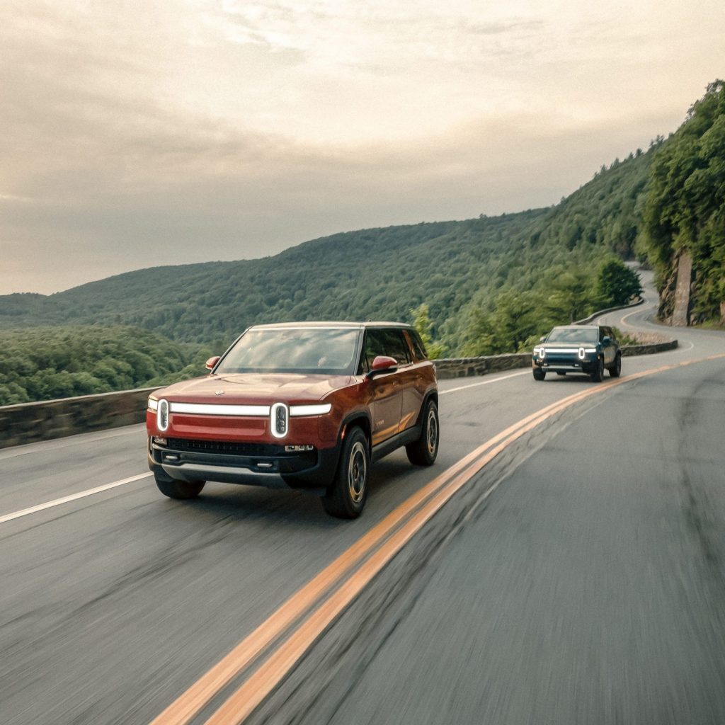 2 Rivian Electric Trucks on a Road