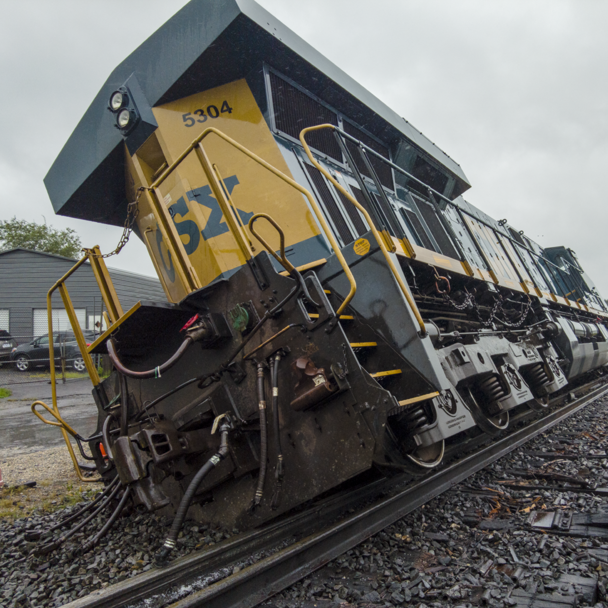 yellow train tilting off of tracks