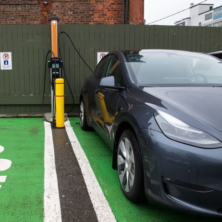 Dark colored Tesla in a charging station