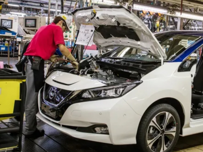 Worker doing work on a nissan leaf engine