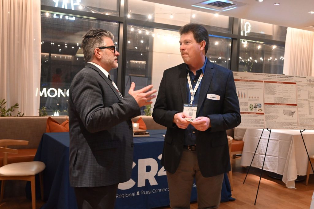 Assistant director Jerry Everett speaking to a conference attendee in front of the CR2C2 booth.