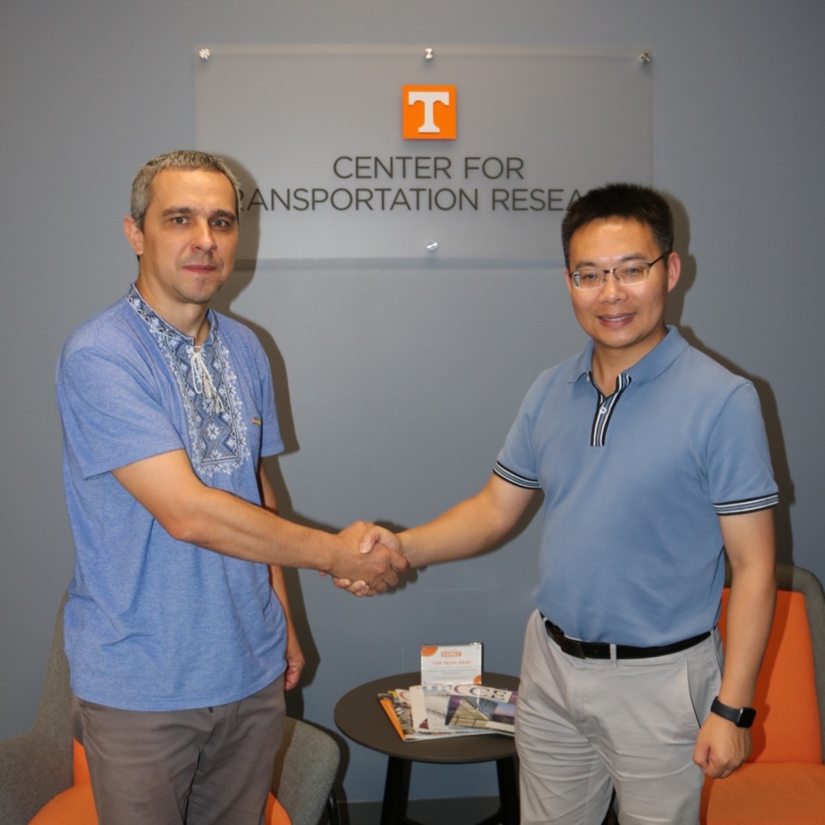 Bondarenko and He shake hands in front of CTR signage.